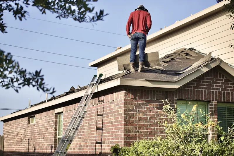Professional roofer working on a residential roof in Margerie Manor